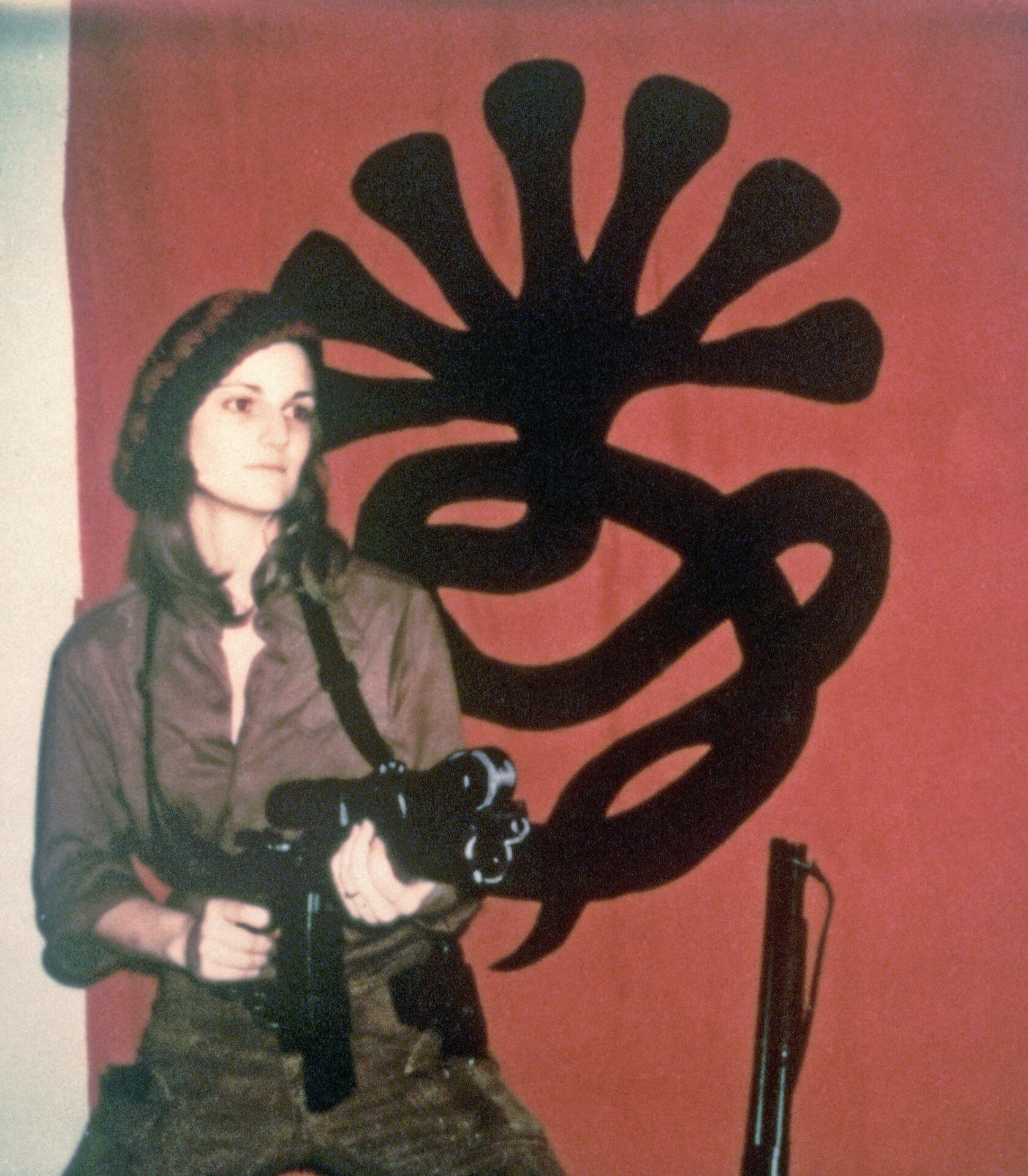 Patty Hearst in front of SLA banner